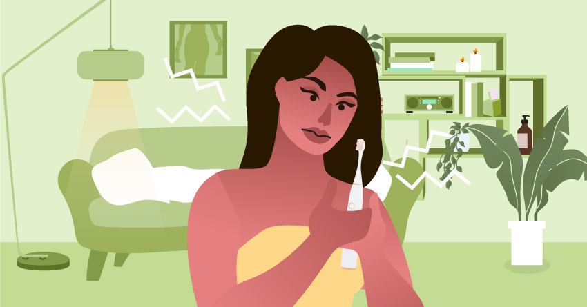 A woman holding a electric toothbrush. 